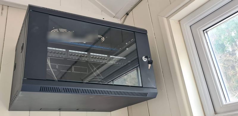 A wall-mounted network cabinet installed in a small office